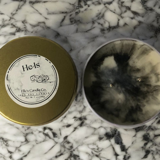 He Is soy candle in a frosted jar, with a clean, masculine scent blend, photographed against a modern neutral background.